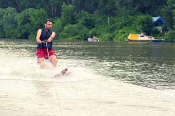 Young man waterskiing on the river on a beautiful summer day