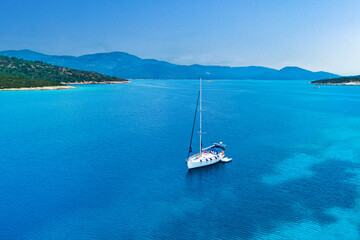 Fototapeta na wymiar Drone photo aerial view of white sailboat in azure turquoise sea bay