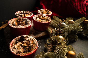 Christmas composition. Christmas cupcakes in red plates. Traditional holiday dessert. Copy space. Dark background.