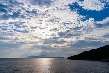 Fototapeta na wymiar 雲の間から友ヶ島へ差し込む太陽の光芒