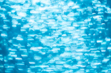 Background light bokeh texture. Beautiful festive Christmas background for the design of congratulations. Nacreous sparkling blue texture.