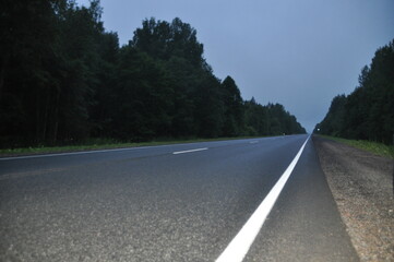 Fototapeta premium asphalt road, car trip view from the window around the field green grass beautiful sky