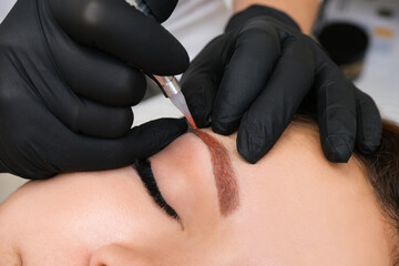 overlapping of unsuccessful permanent makeup on the eyebrows. Applying a warm tone to a cool blue...