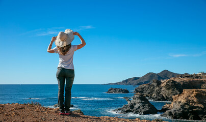 woman looking at seacoast and blue sky © M.studio