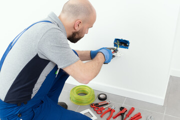 Professional electrician installing a wall socket