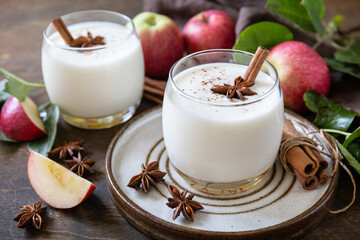Homemade banana apple smoothie with apples, yogurt, cinnamon, spices or lassi in a glass on a...