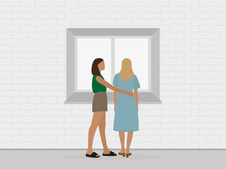 Two young women stand at the window and hug indoors