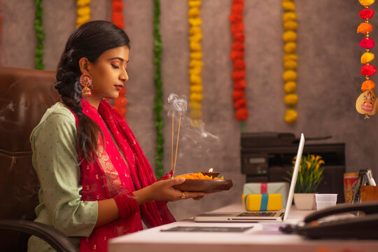 Female employee praying to Godduring Diwali celebration