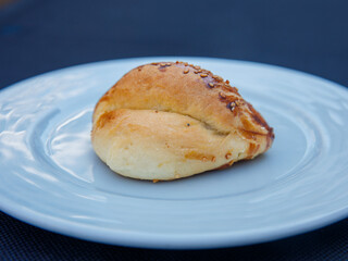Traditional turkish bun pastry product , tasty pogaca with cheese filling on white plate close up