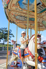 Fototapeta na wymiar メリーゴーランドに乗る女子小学生 (7歳)