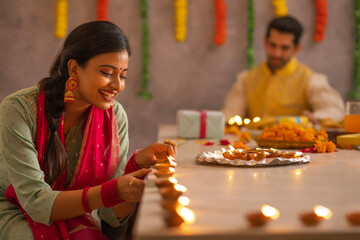 Employees decorating office by placing diyas on table on the occasion of Diwali 
