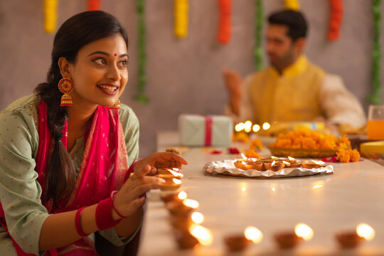 Employees decorating office by placing diyas on table on the occasion of Diwali 