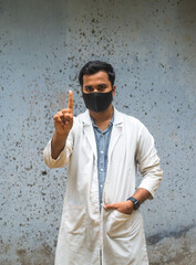 South asian young doctor showing one finger, Bangladeshi medical student isolated wearing apron and...
