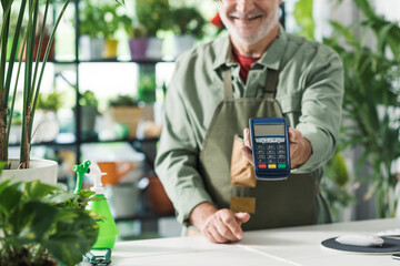 Business owner showing a POS payment terminal - obrazy, fototapety, plakaty