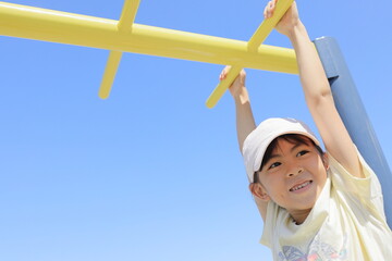 Fototapeta premium 雲梯で遊ぶ女子小学生 (7歳)