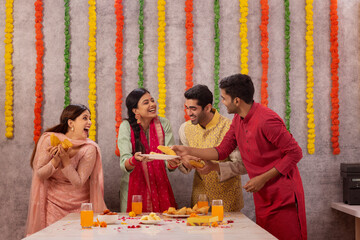 Colleagues eating aloo patties together in office during Diwali celebration