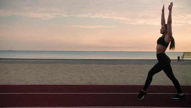 Young woman doing acrobatic activity.Girl training on the beach at sunrise.Doing back flip on playground