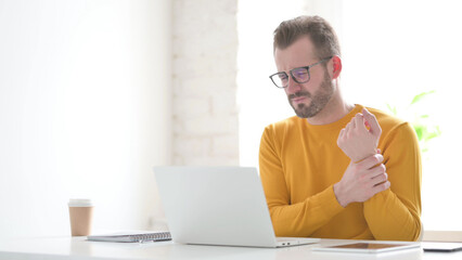 Man having Wrist Pain while using Laptop in Office