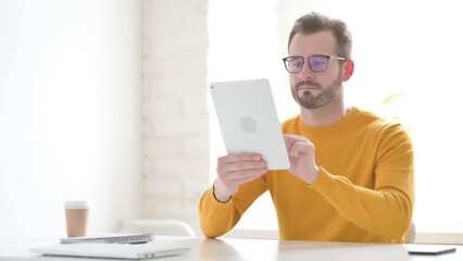 Man using Tablet while Sitting in Office
