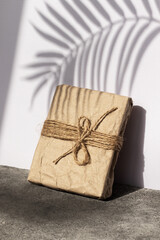 Gift wrapped in kraft paper. Shadow and hard light.