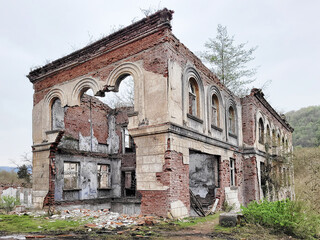 Fototapeta premium Destroyed brick house with arched openings after the war.