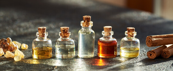 Bottles of essential oil with frankincense or boswellia and cinnamon sticks