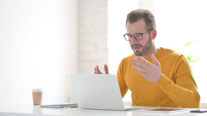 Man Celebrating Success while using Laptop in Office