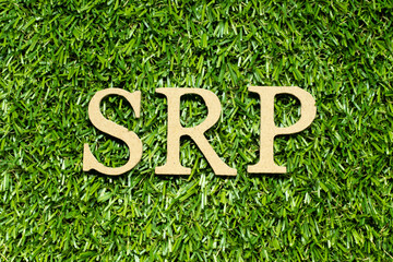 Wood alphabet letter in word SRP (Abbreviation of suggested retail price) on green grass background