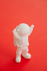 plaster figure of an astronaut on a red background
