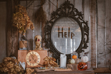 Sinister vintage Halloween decorations with an antique chest of drawers and a mirror with the inscription Help.