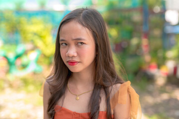 An annoyed young teenage woman scrunches her eyebrows while looking at the person she is furious at.