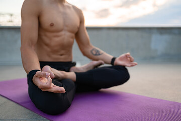 attractive hansome man with athletic strong body doing morning yoga dzen meditation