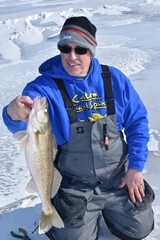 An ice angler with a walleye