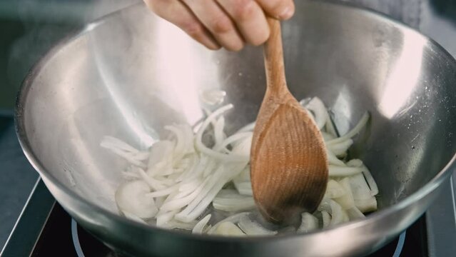 close up video of chef preparing onion in frying pan.