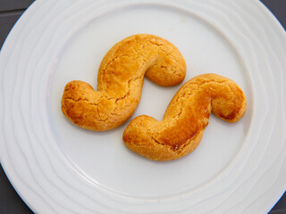 Esse biscuits, S italian cookies in english on white plate. They are home made butter biscuit originating from the autonomous region of Friuli, in Italy. Top view