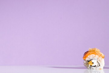 Delicious sushi rolls on violet background
