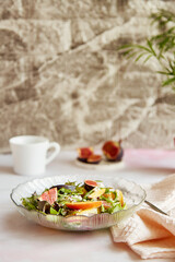 Fototapeta na wymiar Aesthetic fresh salad of potato, arugula, grain cheese, peach and figs. Mediterranean healthy dish, vegan salad, easy recipe
