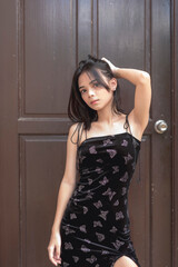 A sexy Southeast Asian young lady in her early 20s fiercely looks at the camera as she holds up her...