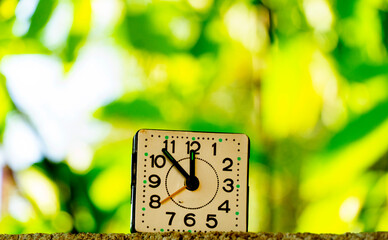 vintage avintage alarm clock against  autumn leaves bokeh, morning shot