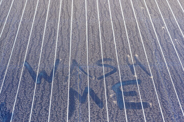 Dust covered solar panel with Wash Me sated 