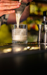 man hand bartender making cocktail in glass on the bar counter