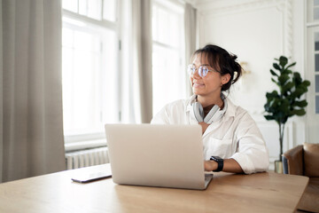 A woman in the office is working on an online startup project using a laptop computer.