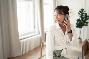 A woman in the office is working on a project online using a laptop computer.