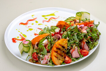 Fresh salad with ham and arugula, with grilled persimmon.