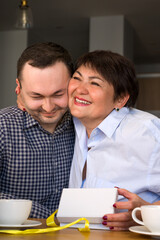 Happy mother hugging son while holding present. Mother's day or 8 march concept.Vertical banner