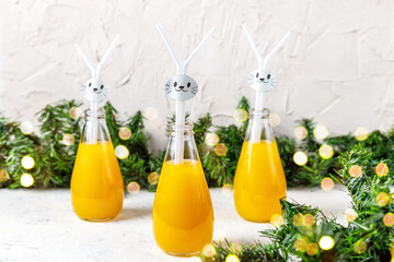 Orange drink decorated with white rabbit on light background for children party.