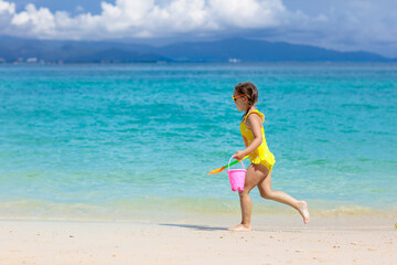 Kids play on tropical beach. Sand and water toy.