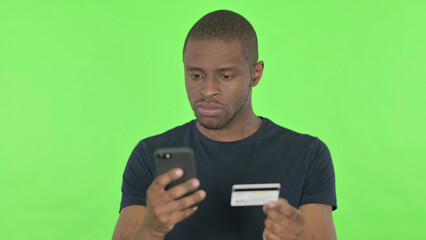 Online Shopping on Smartphone by African Man on Green Background