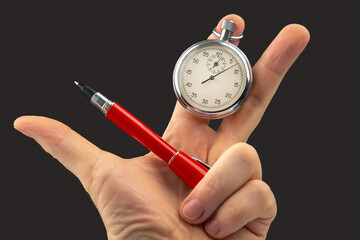 hand with a mechanical analog stopwatch on a dark background. Time part precision. Measurement of the speed interval