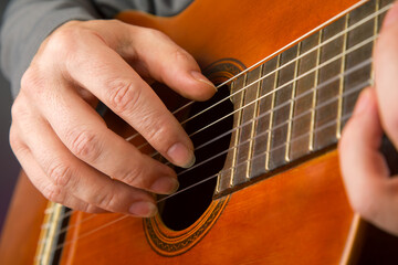 man plays the classical guitar. string musical instrument. hands of the musician playing on classical guitar